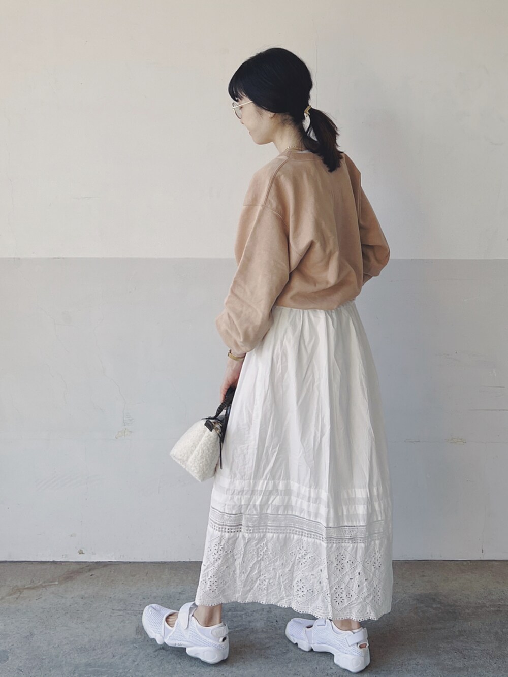 その他のスウェット、ホワイト系のスカート、ホワイト系のハンドバッグを着用したレディースの春コーディネートの3枚目の写真