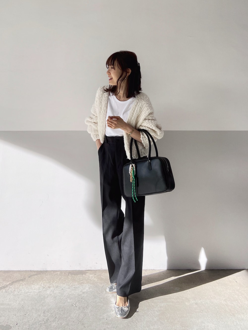ホワイト系のカーディガン/ボレロ、ホワイト系のTシャツ/カットソー、ブラック系のボストンバッグを着用したレディースの秋コーディネートの2枚目の写真