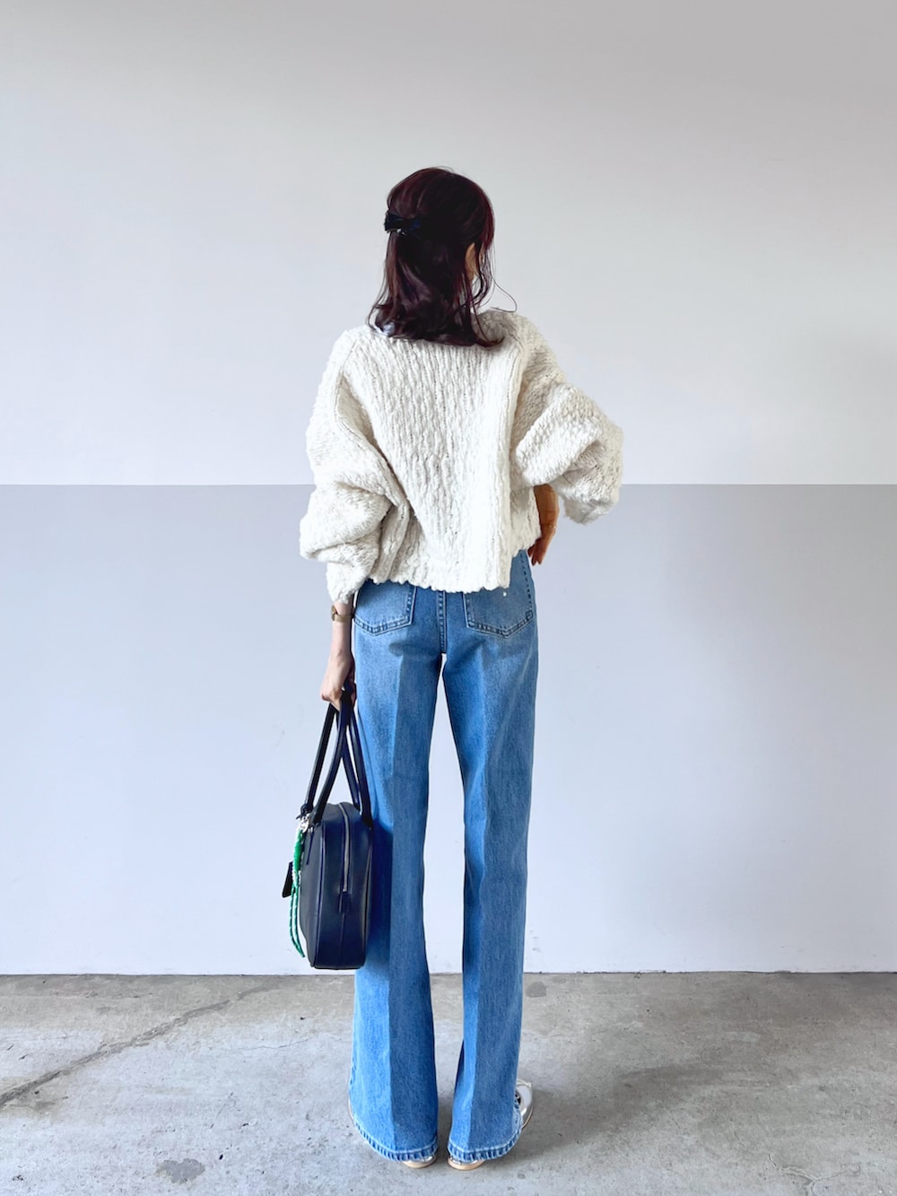 ホワイト系のカーディガン/ボレロ、ホワイト系のTシャツ/カットソー、ブルー系のデニムパンツを着用したレディースの秋コーディネートの2枚目の写真