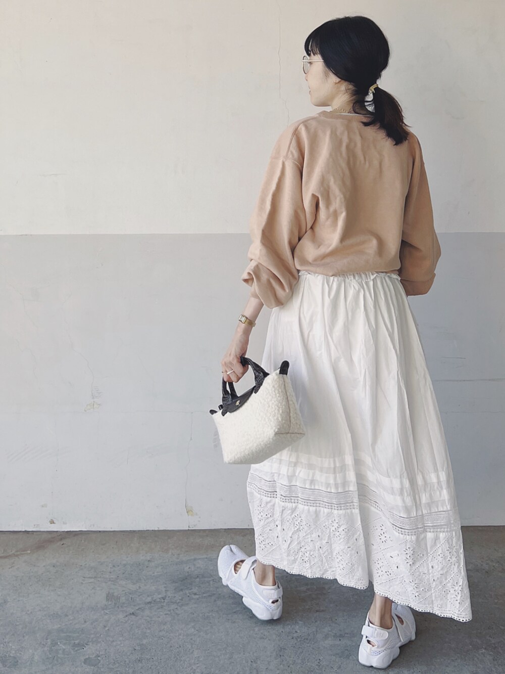 その他のスウェット、ホワイト系のスカート、ホワイト系のハンドバッグを着用したレディースの春コーディネートの2枚目の写真