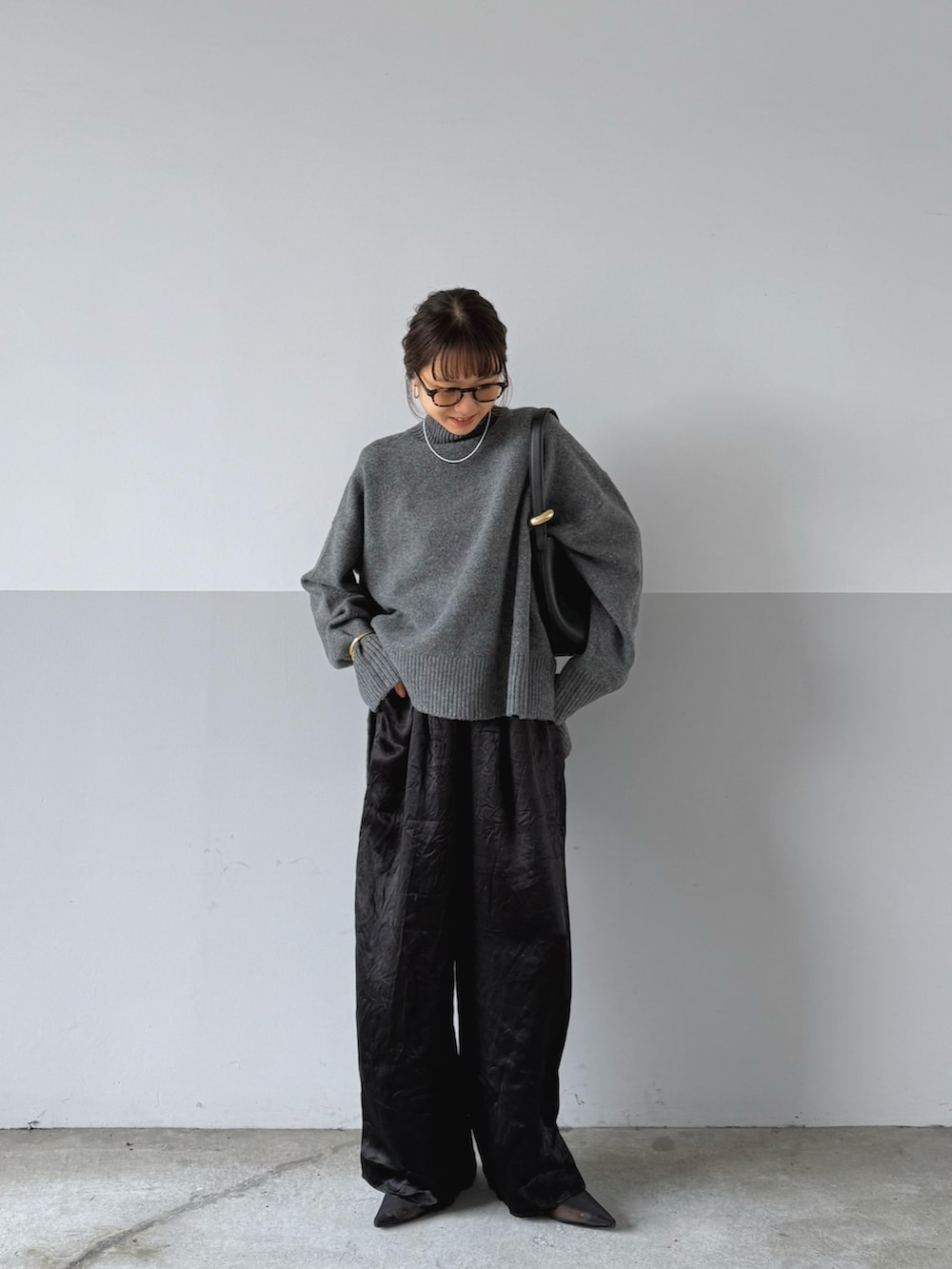 ブラック系のトートバッグ、グレー系のニット/セーター、ブラック系のその他パンツを着用したレディースの秋コーディネートの2枚目の写真