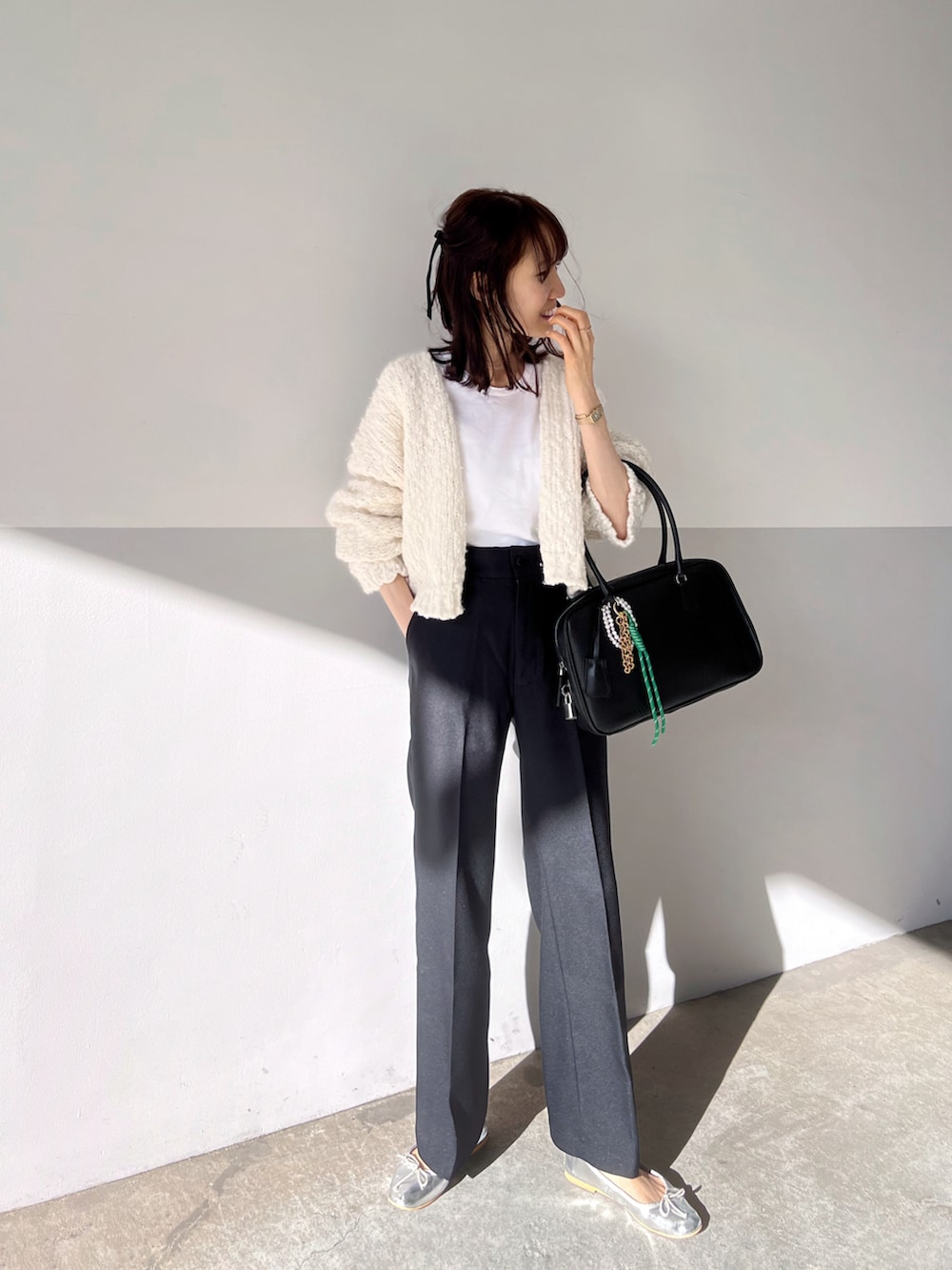 ホワイト系のカーディガン/ボレロ、ホワイト系のTシャツ/カットソー、ブラック系のボストンバッグを着用したレディースの秋コーディネートの3枚目の写真