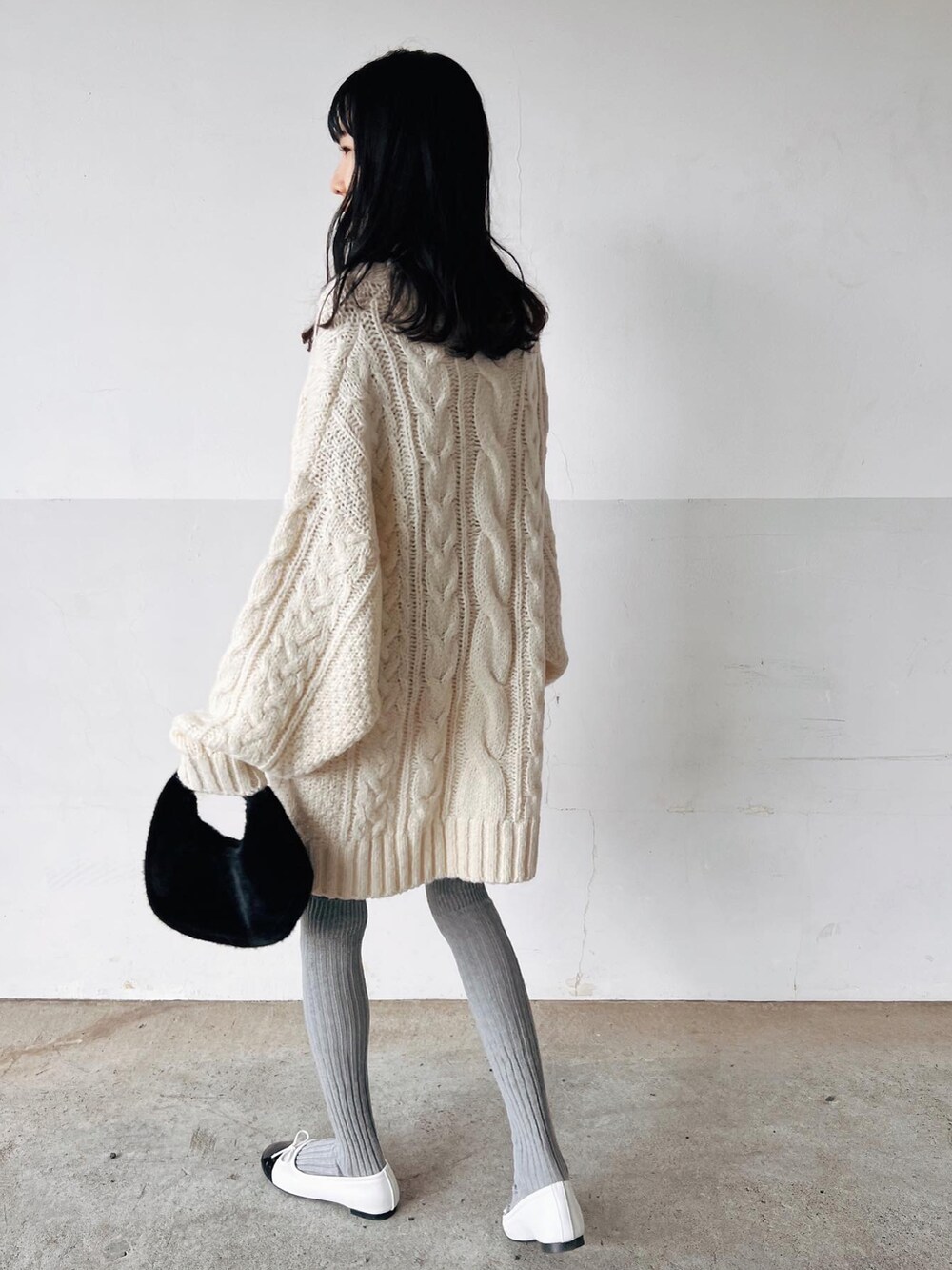 ホワイト系のニット/セーター、ブラック系のハンドバッグ、ホワイト系のバレエシューズを着用したレディースの春コーディネートの2枚目の写真