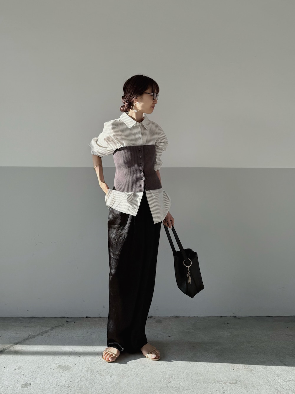 グレー系のニット/セーター、ブラック系のその他パンツを着用したレディースの秋コーディネートの2枚目の写真