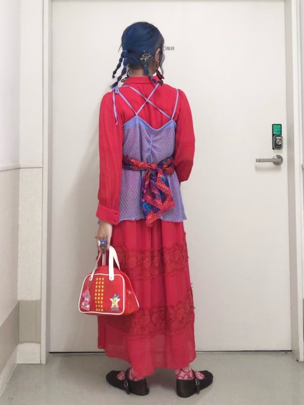 レッド系のハンドバッグ、レッド系のワンピース、パープル系のキャミソールを着用したレディースの秋コーディネートの2枚目の写真