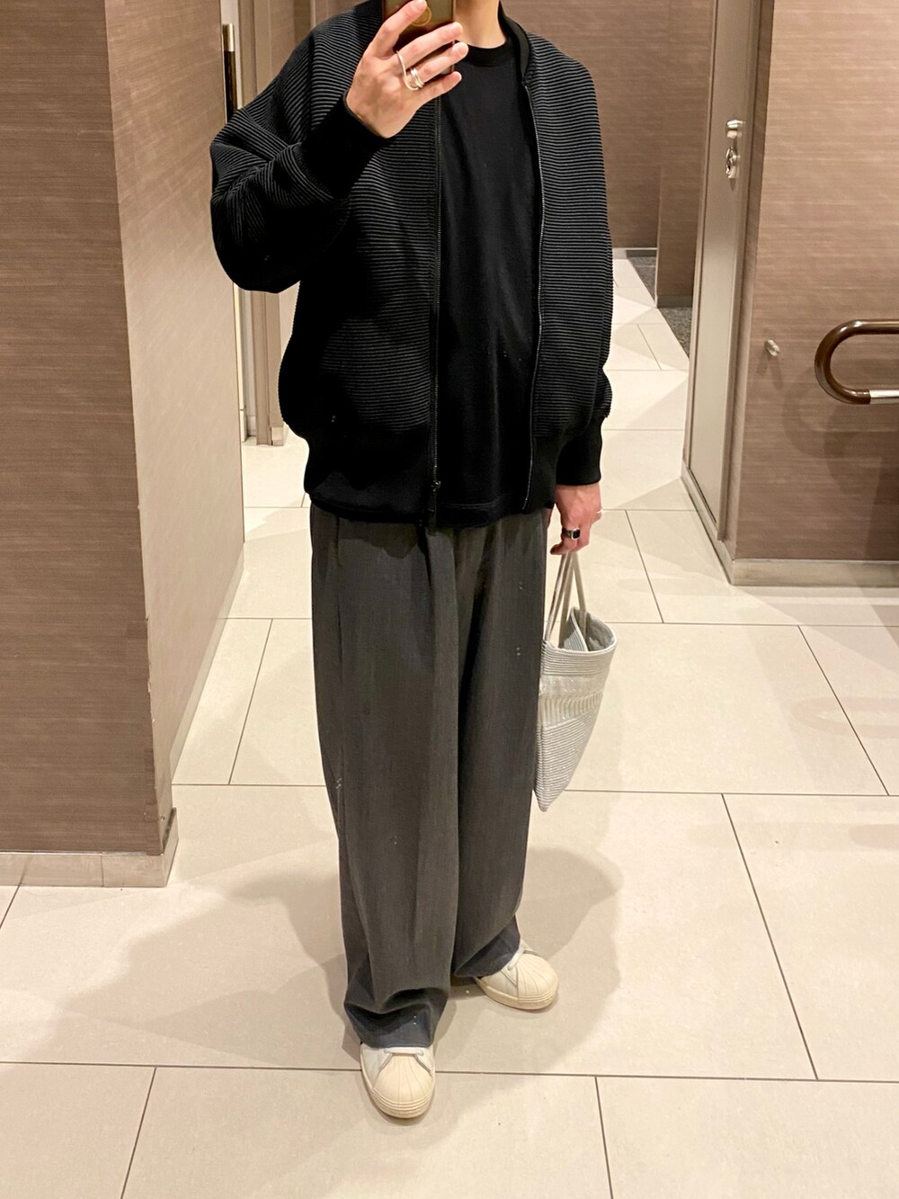 ブラック系のトップス、ブラック系のTシャツ/カットソー、グレー系のスラックスを着用したメンズの秋コーディネートの2枚目の写真