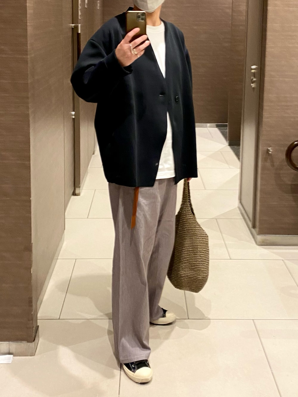 ホワイト系のTシャツ/カットソー、グレー系のデニムパンツ、ブラック系のスニーカーを着用したメンズの秋コーディネートの2枚目の写真
