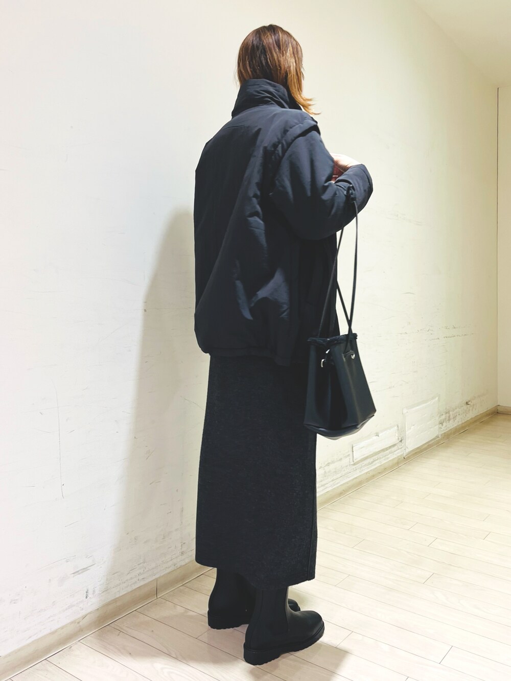 ブラック系のノーカラージャケット、ブラック系のスカートを着用したレディースの冬コーディネートの2枚目の写真