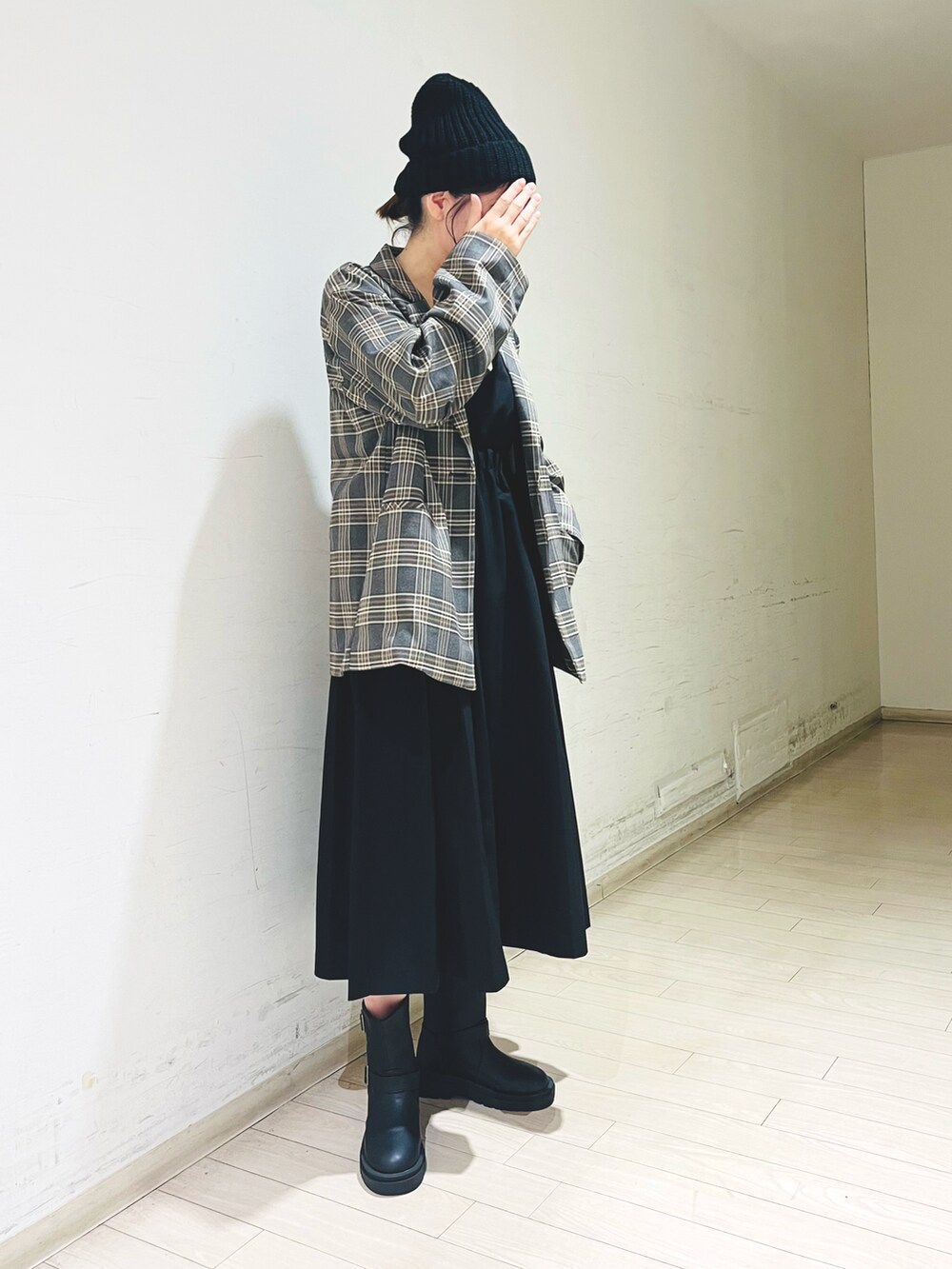 ブラック系のワンピース、グレー系のノーカラージャケット、ブラック系のブーツを着用したレディースの秋コーディネートの2枚目の写真