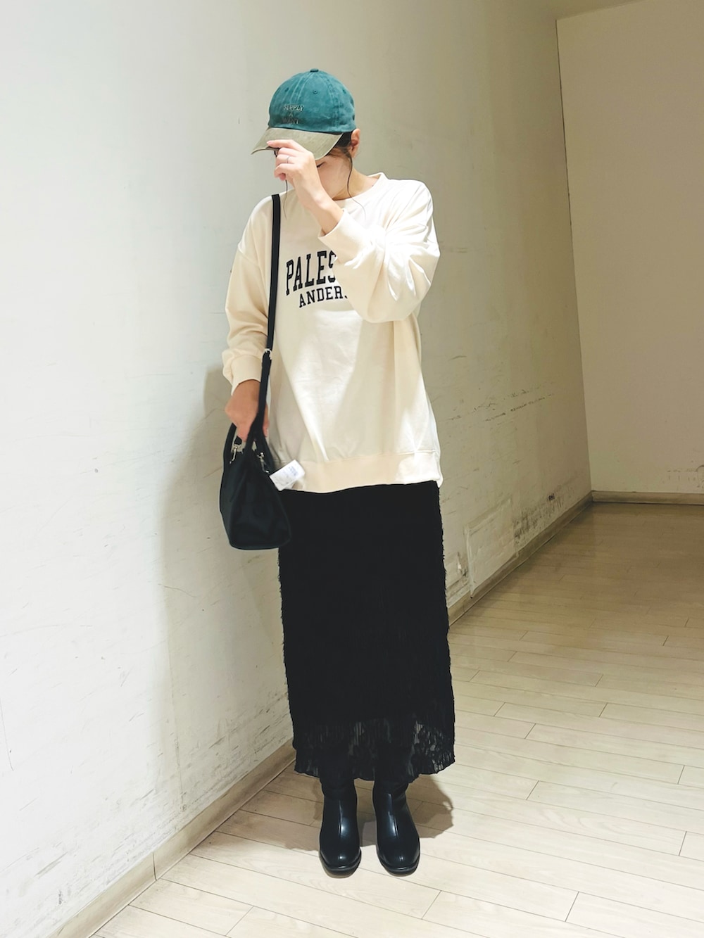 ホワイト系のTシャツ/カットソー、ブラック系のスカート、ブラック系のハンドバッグを着用したレディースの秋コーディネートの2枚目の写真