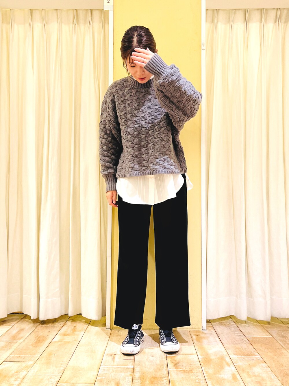 グレー系のニット/セーター、ブラック系のその他パンツ、ホワイト系のシャツ/ブラウスを着用したレディースの秋コーディネートの2枚目の写真