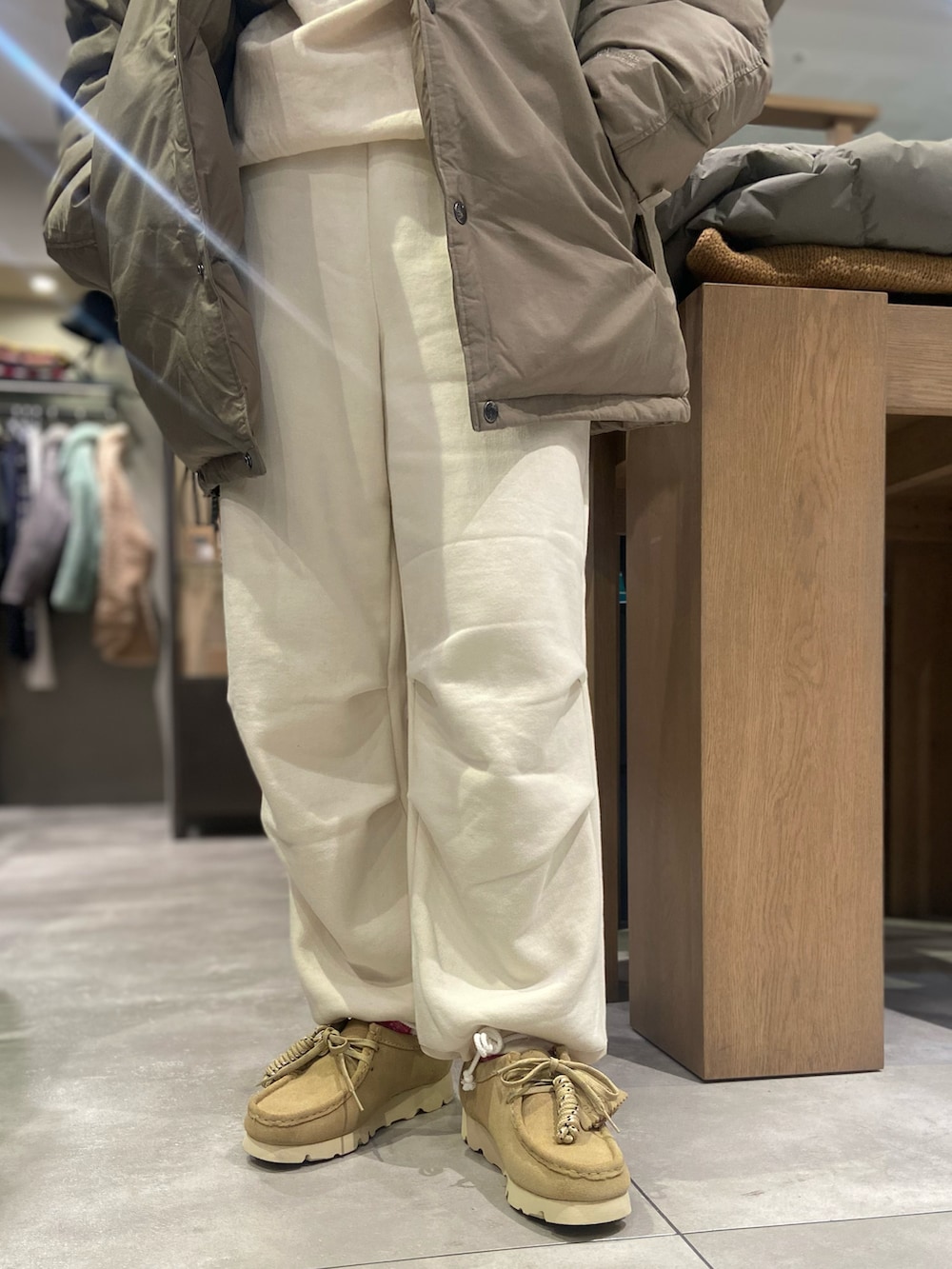 ベージュ系のモカシン/デッキシューズ、ホワイト系のスウェット、ブラック系のダウンジャケット/コートを着用したレディースの秋コーディネートの3枚目の写真