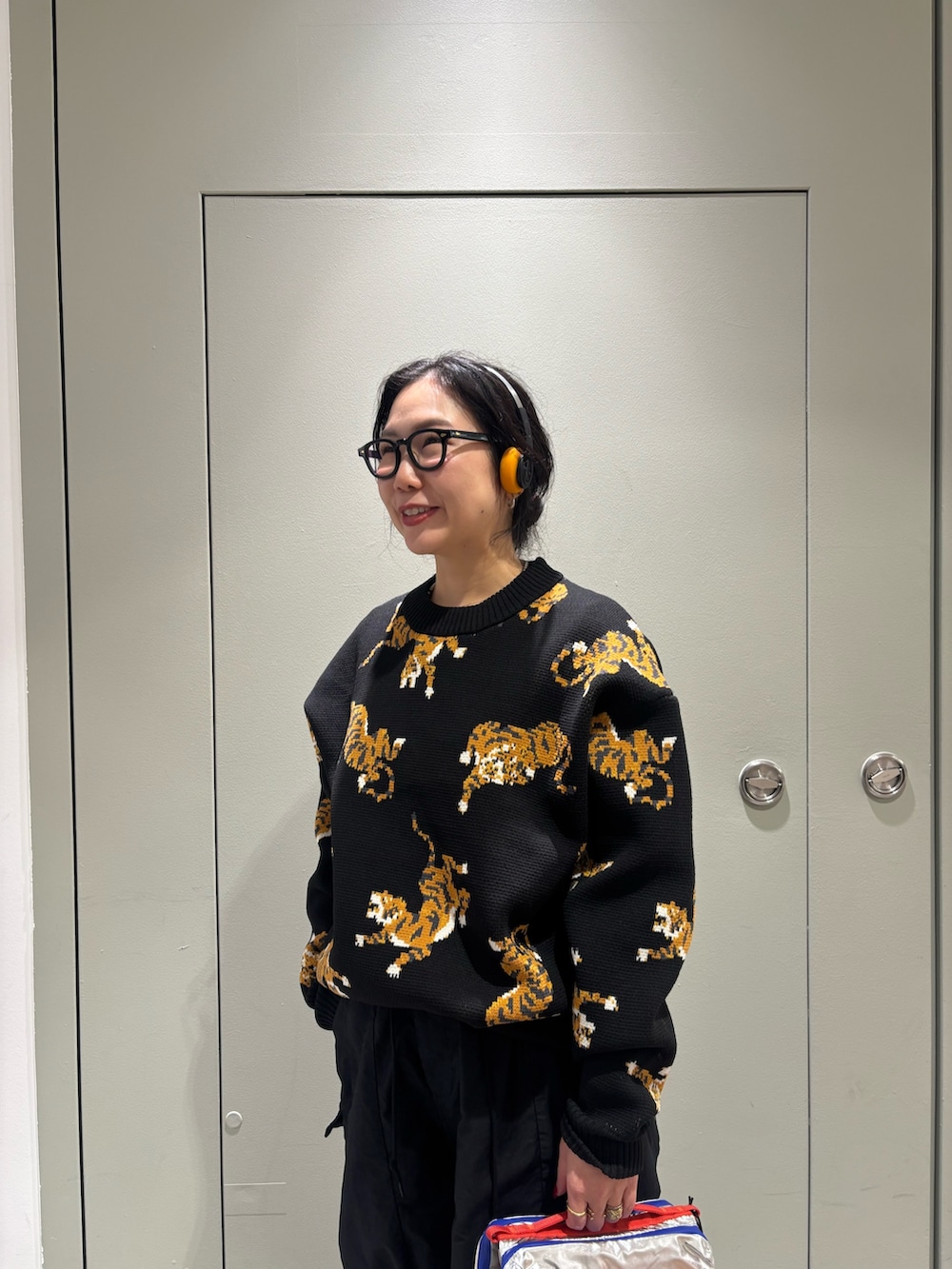 ブラック系のニット/セーター、ブラック系のヘッドフォン/イヤホンを着用したレディースの秋コーディネートの2枚目の写真