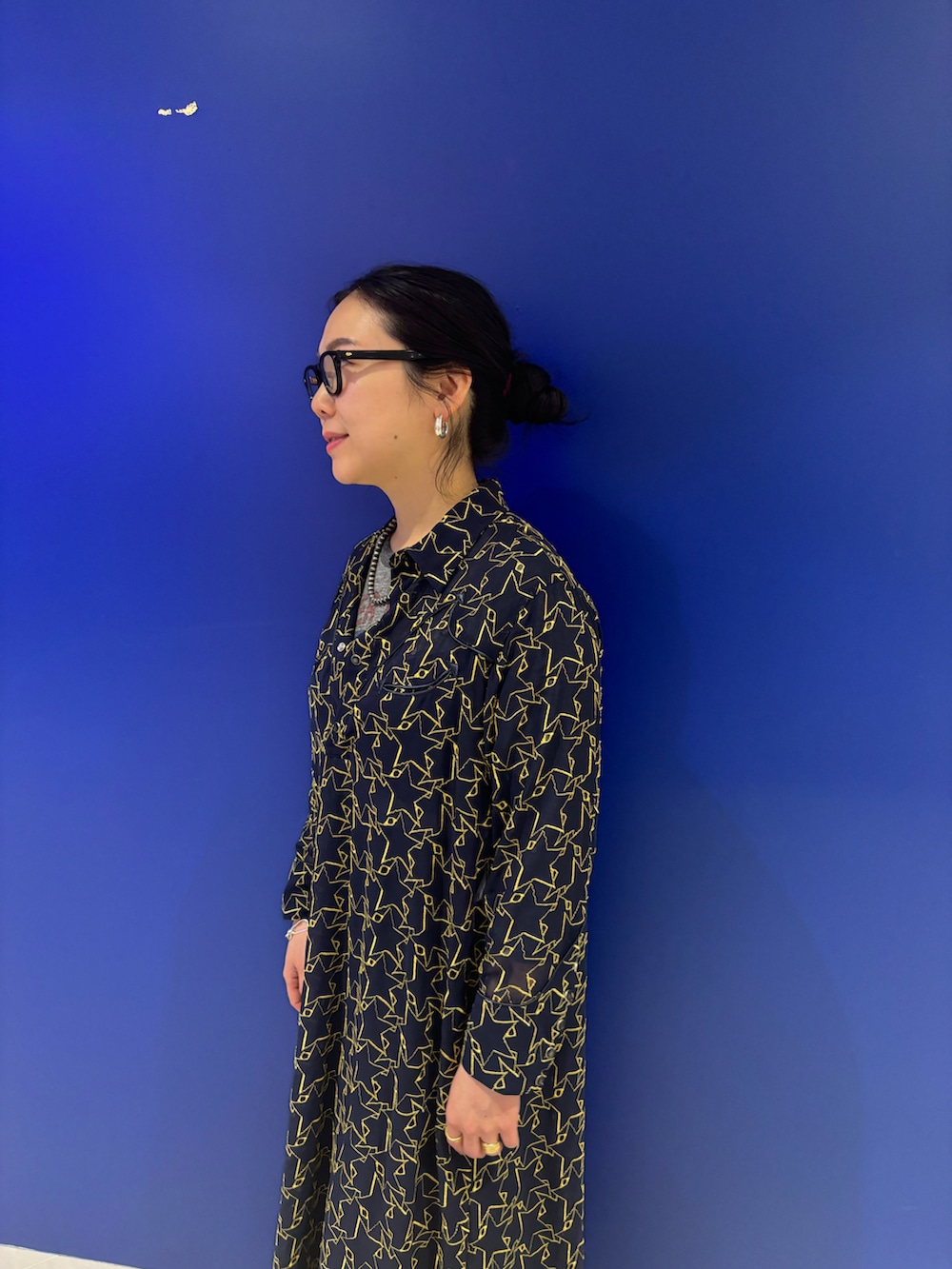 ブラック系のサンダル、ブラック系のショルダーバッグ、ブルー系のスマホグッズを着用したレディースの春コーディネートの2枚目の写真