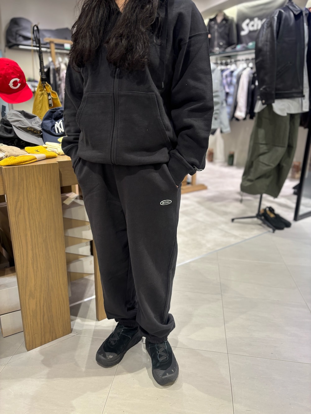 ブラック系のパーカー、ブラック系のスウェットパンツを着用したレディースの春コーディネートの3枚目の写真