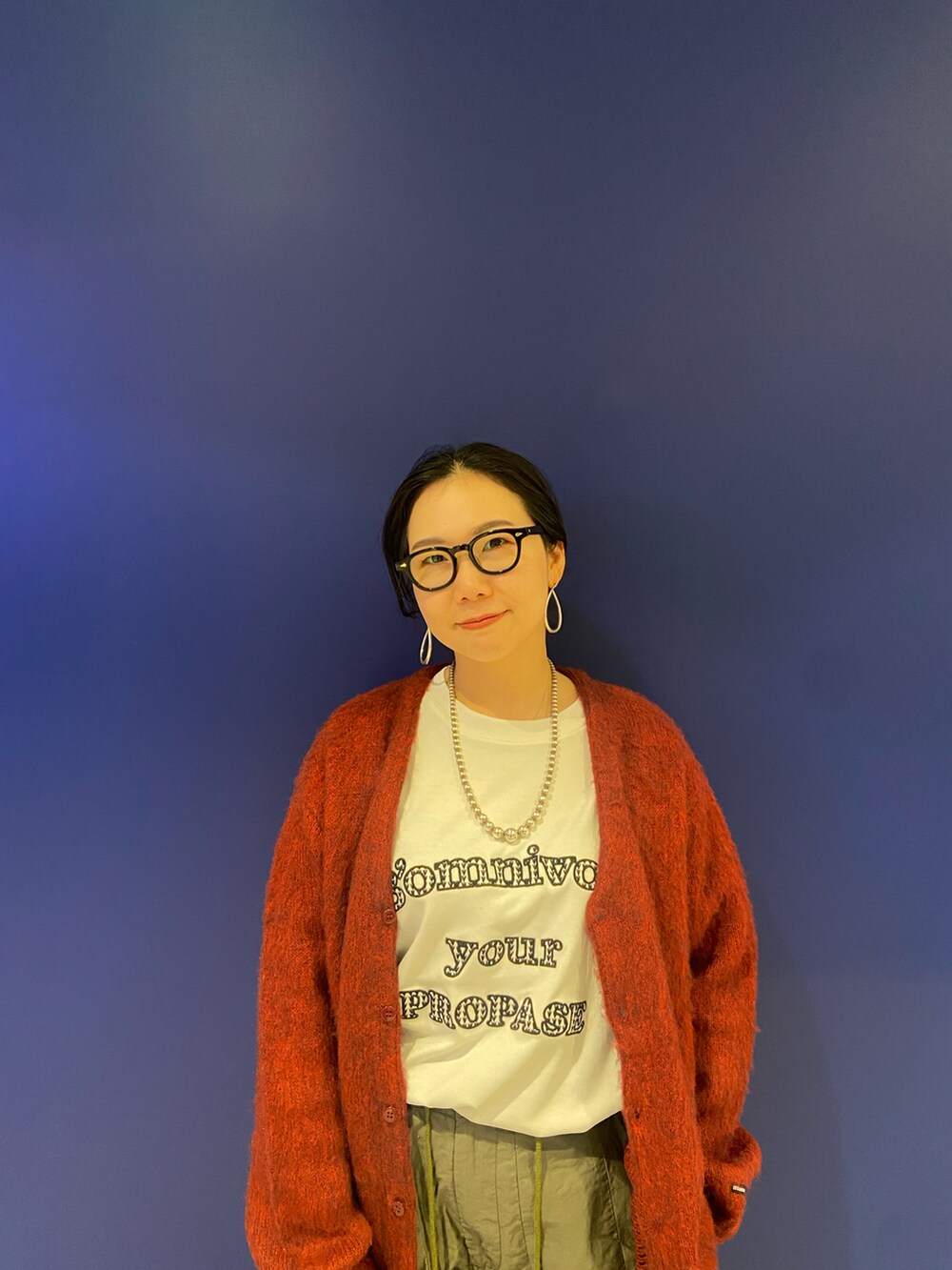 ブラック系のモカシン/デッキシューズ、ホワイト系のTシャツ/カットソー、レッド系のカーディガン/ボレロを着用したレディースの秋コーディネートの2枚目の写真