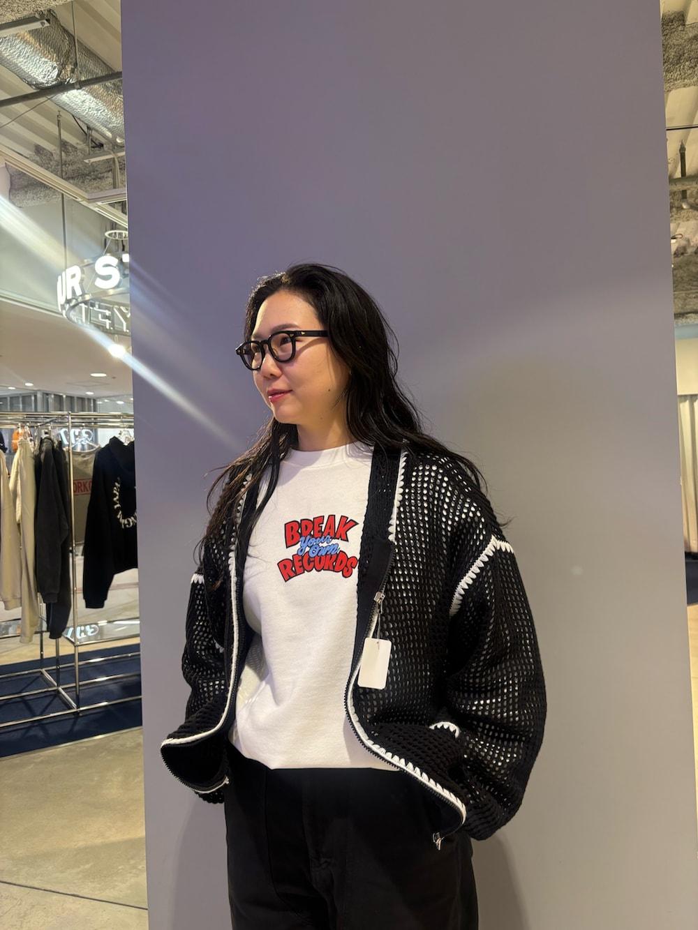 ブラック系のパーカー、ホワイト系のスウェットを着用したレディースの春コーディネートの2枚目の写真