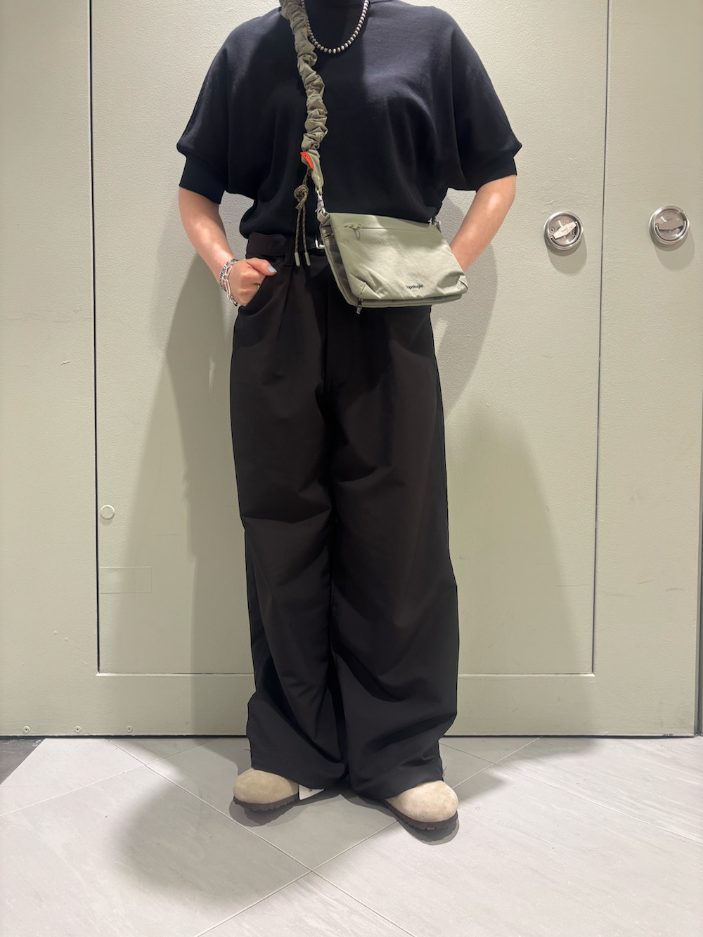 「夏、ショルダーバッグ、ブラックコーデ、BEAVER、ワイドパンツ、ビルケンシュトック、ボストン、黒ニット、黒Tシャツ、BEAVER名古屋」｜「TopologieのTopologie/トポロジー Bungee Strap バンジーストラップ【ストラップ単体】（スマホグッズ、ベージュ系）」を使った、小林さん（レディース・155cm）の春コーディネートの2枚目の写真