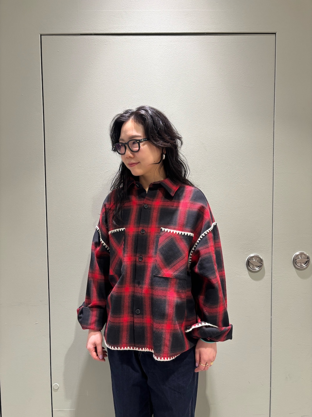 レッド系のシャツ/ブラウス、ブラック系のデニムパンツを着用したレディースの冬コーディネートの3枚目の写真