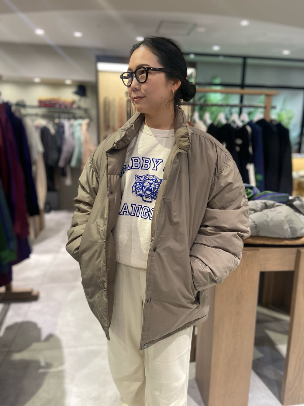 ベージュ系のモカシン/デッキシューズ、ホワイト系のスウェット、ブラック系のダウンジャケット/コートを着用したレディースの秋コーディネートの2枚目の写真