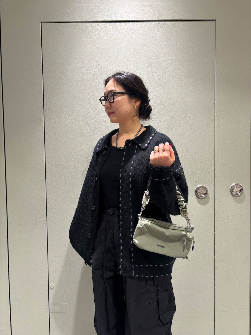 ブラック系のカーディガン/ボレロ、グレー系のショルダーバッグを着用したレディースの秋コーディネートの2枚目の写真