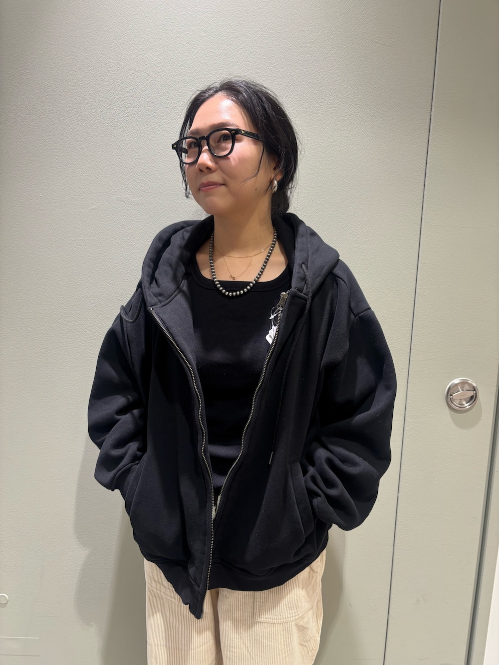 ブラック系のパーカーを着用したレディースの冬コーディネートの2枚目の写真