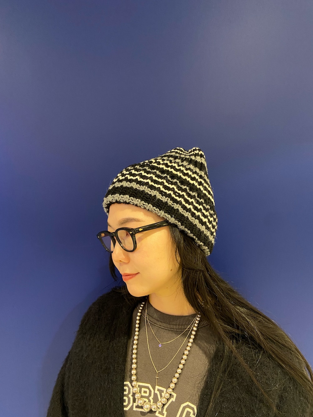 ブルー系のカーディガン/ボレロ、ブラック系のスウェット、ベージュ系のモカシン/デッキシューズを着用したレディースの冬コーディネートの4枚目の写真