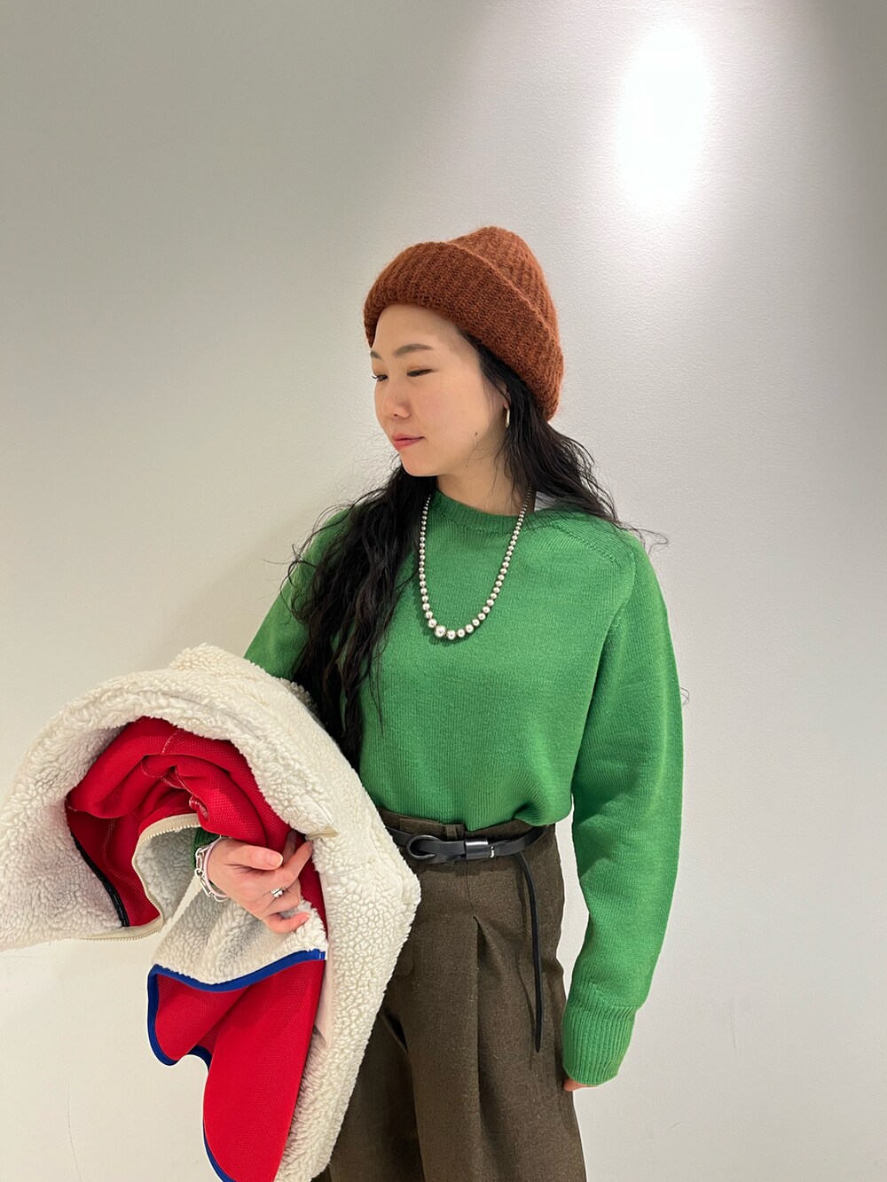 ブラウン系のブルゾン、ピンク系のニット/セーター、ブラウン系のニットキャップ/ビーニーを着用したレディースの冬コーディネートの2枚目の写真