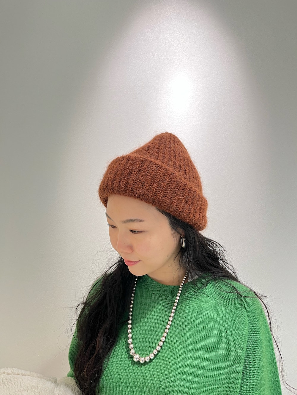 ブラウン系のブルゾン、ピンク系のニット/セーター、ブラウン系のニットキャップ/ビーニーを着用したレディースの冬コーディネートの3枚目の写真