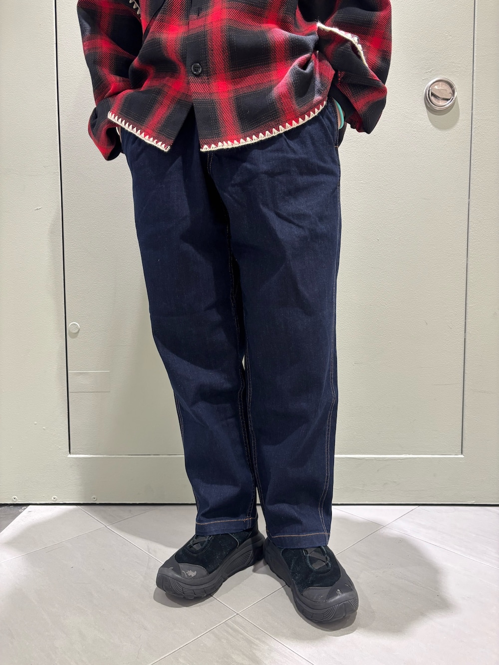 レッド系のシャツ/ブラウス、ブラック系のデニムパンツを着用したレディースの冬コーディネートの2枚目の写真