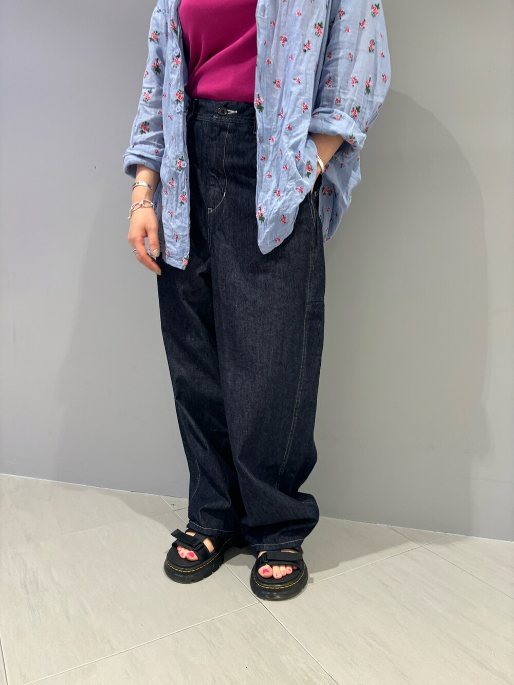 ブルー系のデニムパンツ、ブラック系のサンダルを着用したレディースの夏コーディネートの3枚目の写真