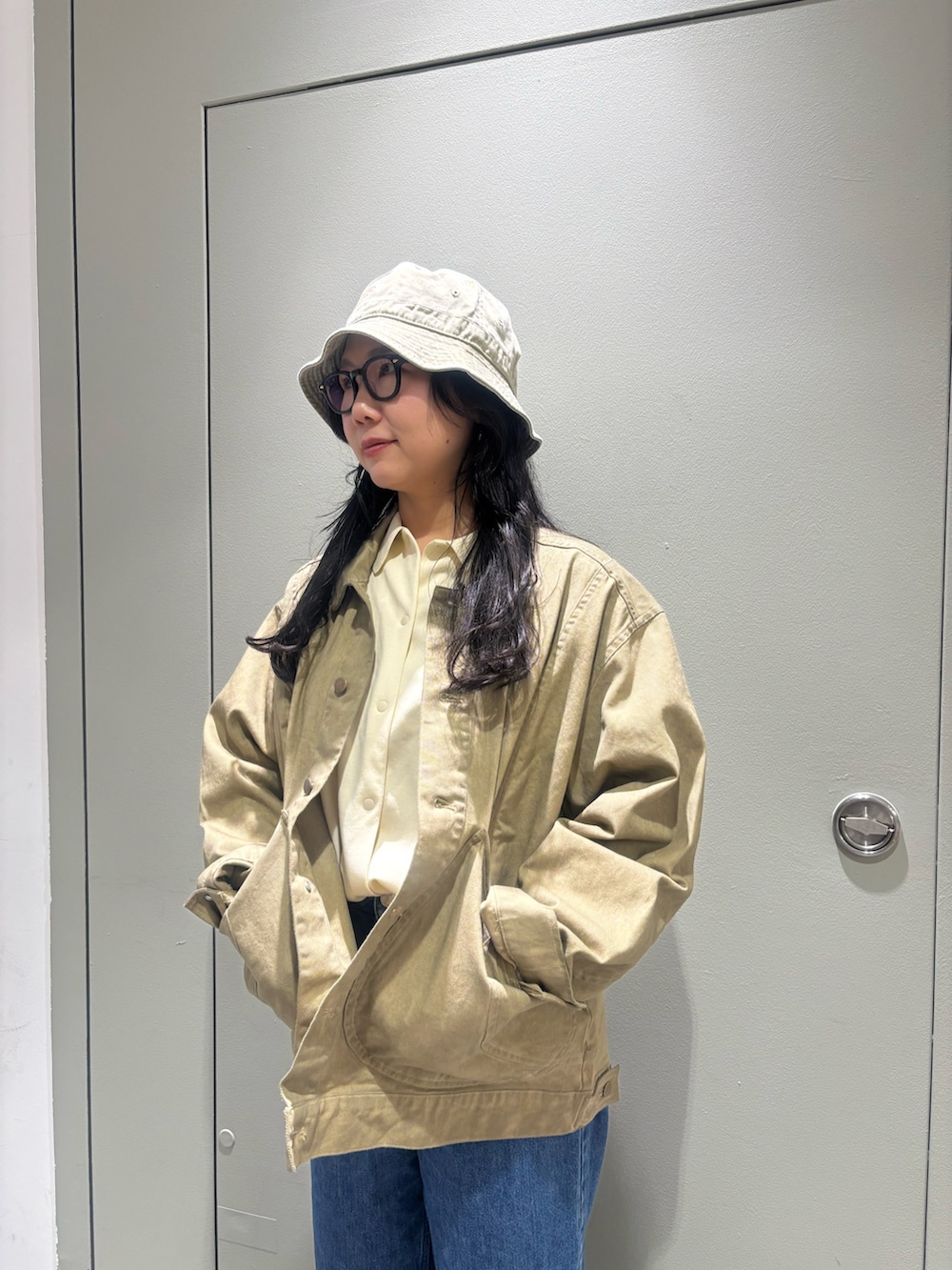イエロー系のブルゾン、グリーン系のハットを着用したレディースの春コーディネートの2枚目の写真