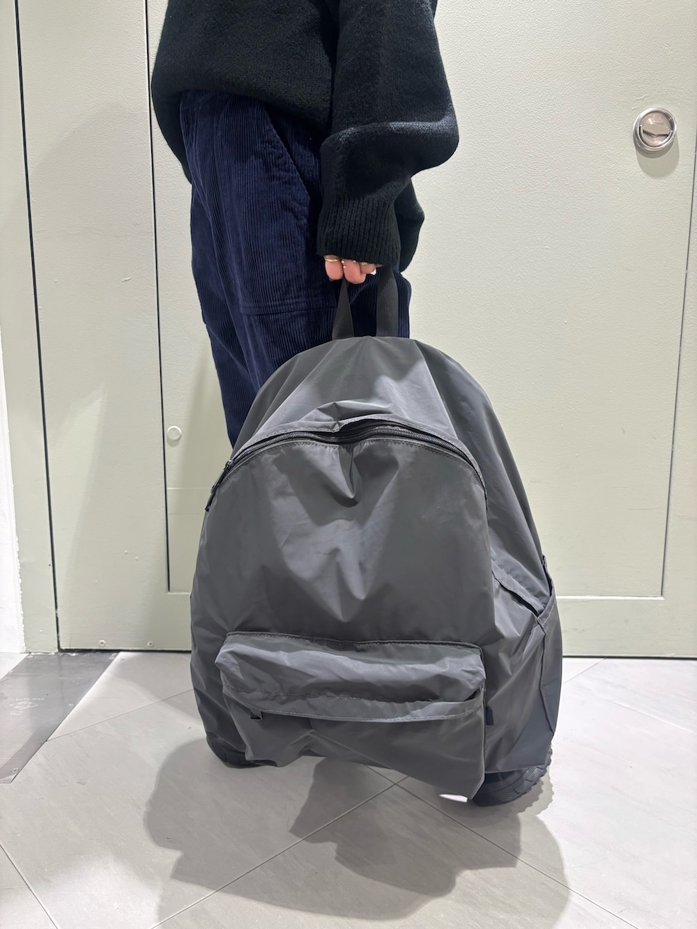 ブラック系のニット/セーター、ブラック系のバックパック/リュックを着用したレディースの冬コーディネートの2枚目の写真