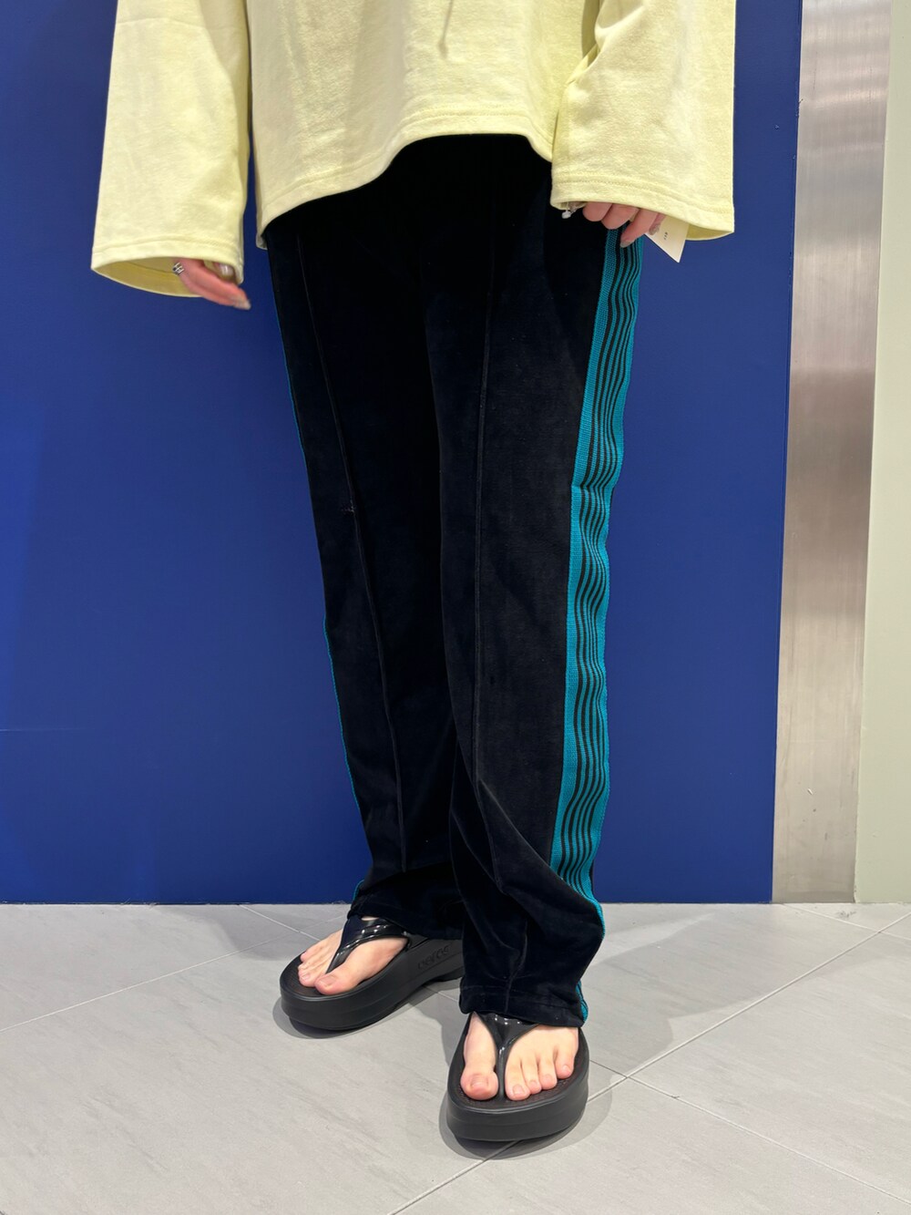 イエロー系のTシャツ/カットソー、ブラック系のサンダル、グレー系のショルダーバッグを着用したレディースの春コーディネートの3枚目の写真