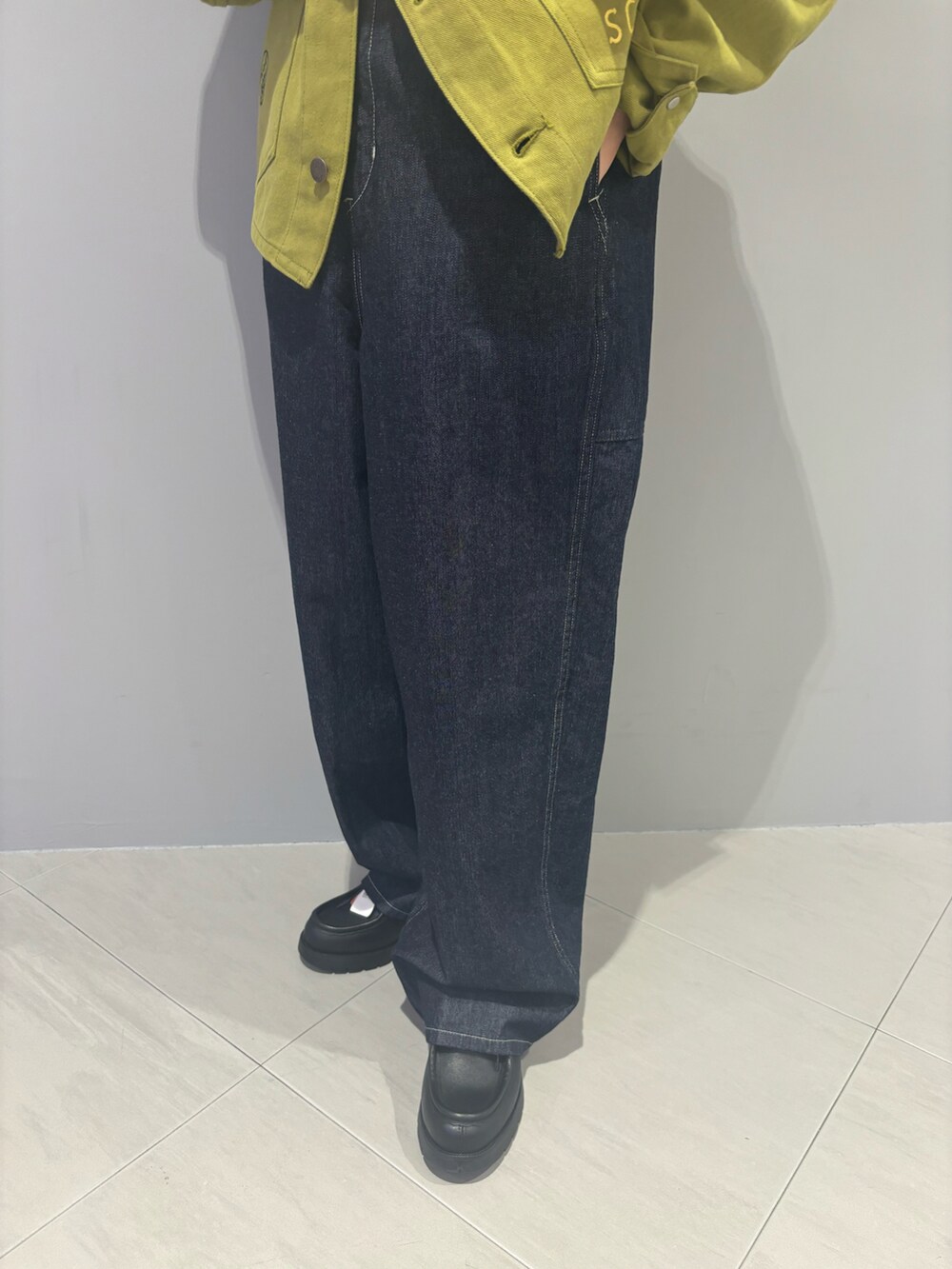 ブルー系のデニムパンツ、ブラック系のローファー、ベージュ系のTシャツ/カットソーを着用したレディースの夏コーディネートの4枚目の写真