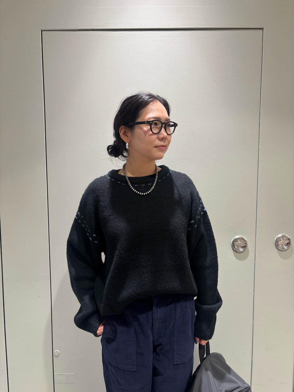 ブラック系のニット/セーター、ブラック系のバックパック/リュックを着用したレディースの冬コーディネートの3枚目の写真