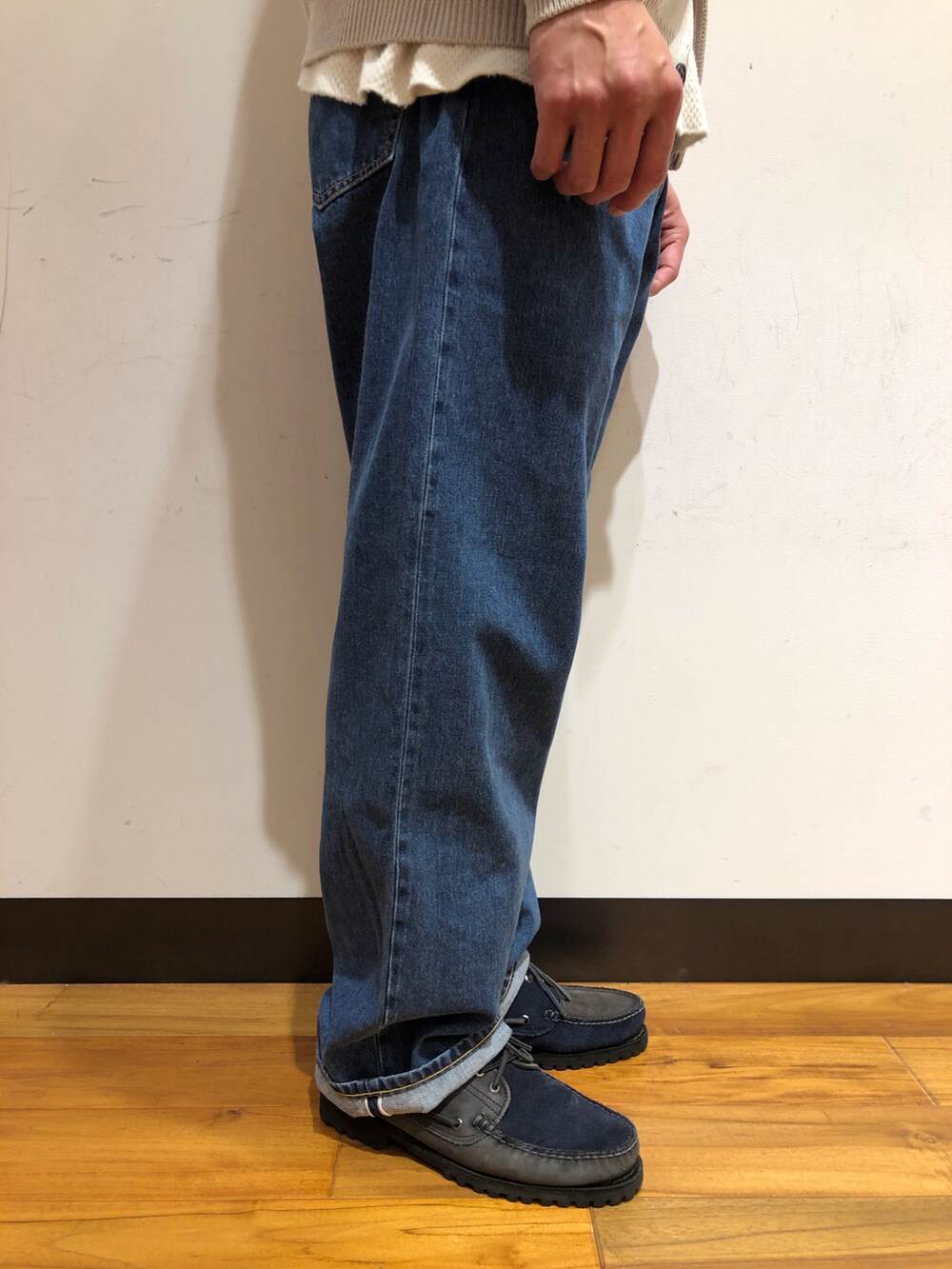 グレー系のニット/セーター、グリーン系のステンカラーコート、ブルー系のシューズを着用したメンズの冬コーディネートの5枚目の写真