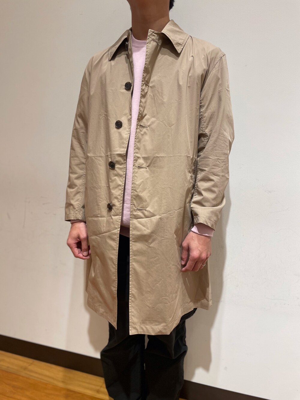 ピンク系のスウェット、ベージュ系のステンカラーコート、ブラック系のカーゴパンツを着用したメンズの冬コーディネートの2枚目の写真