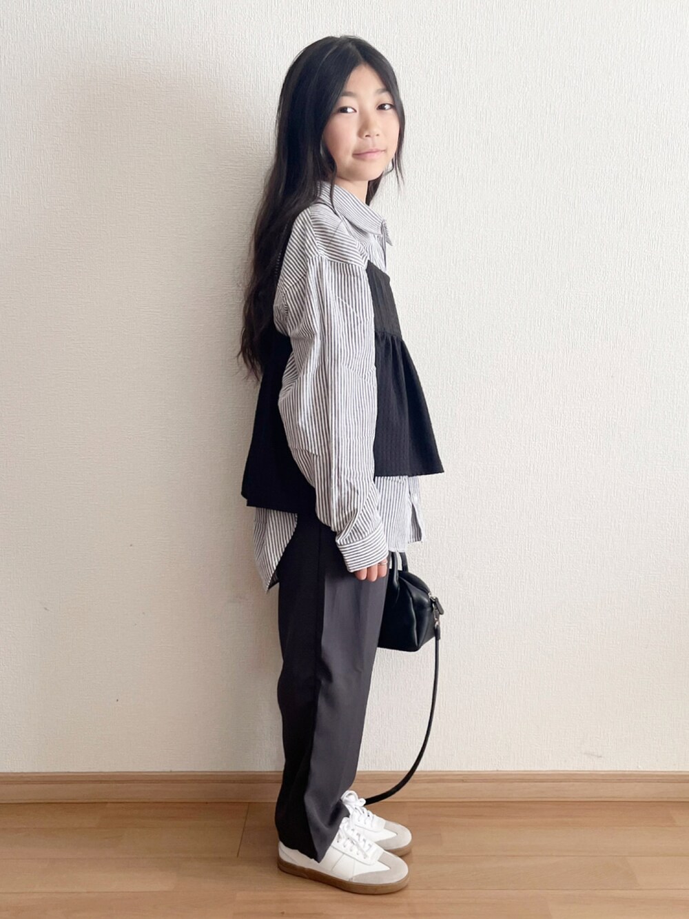 グレー系のパンツ、グレー系のシャツ/ブラウス、ブラック系のキャミソールを着用したキッズの春コーディネートの3枚目の写真
