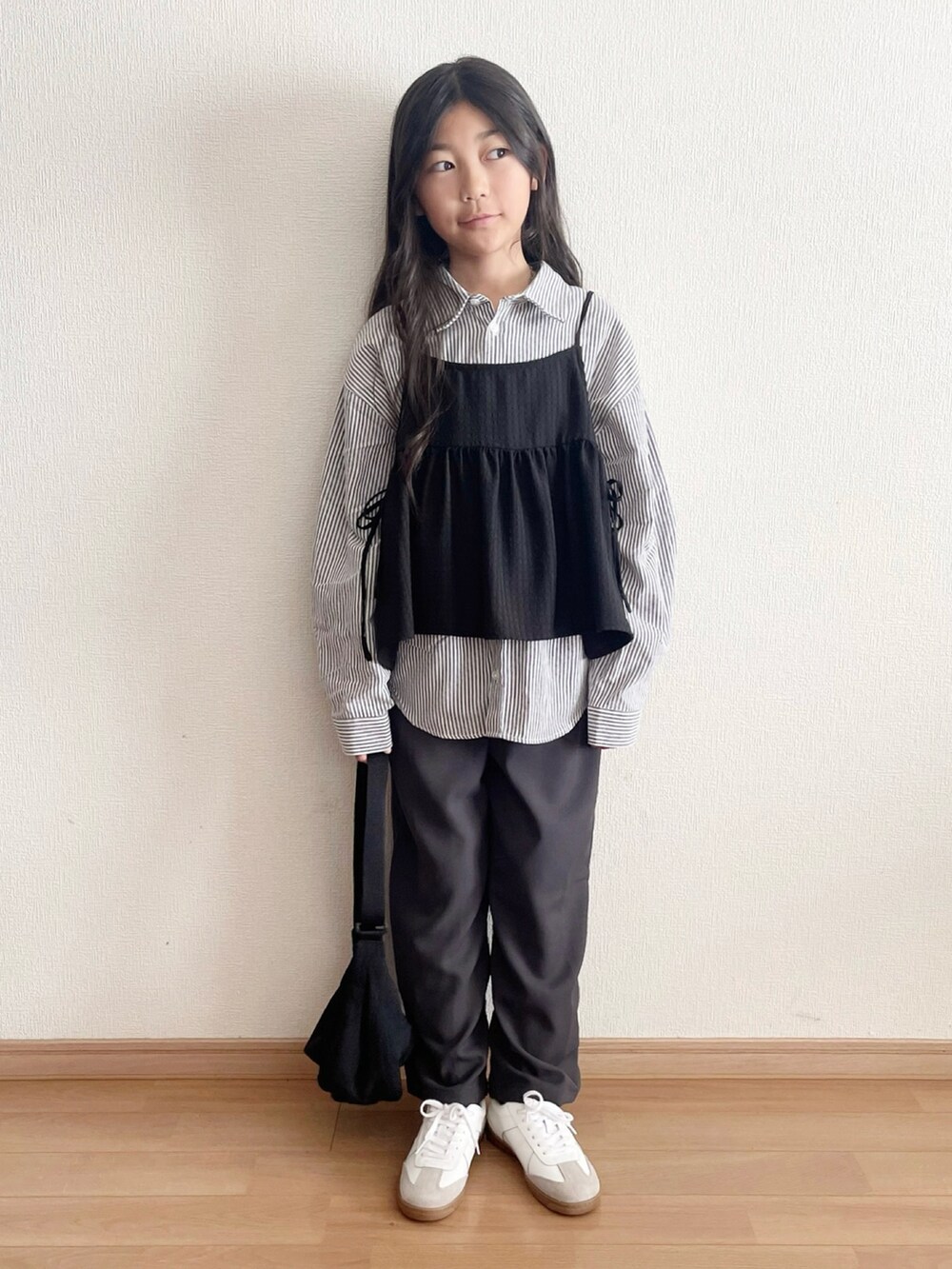 グレー系のパンツ、グレー系のシャツ/ブラウス、ブラック系のキャミソールを着用したキッズの春コーディネートの2枚目の写真