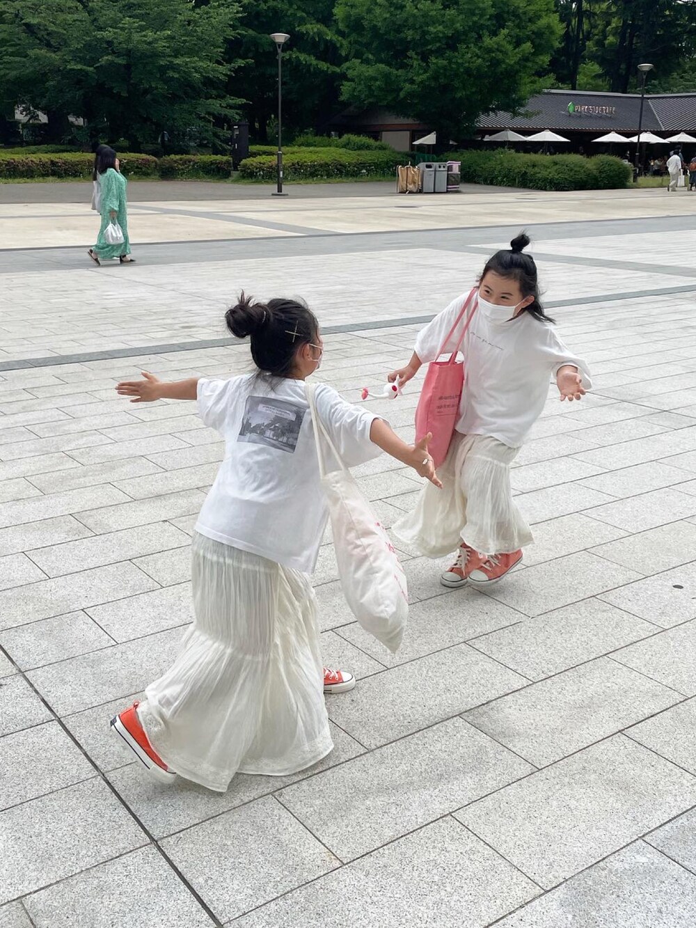 ホワイト系のスカート、ホワイト系のTシャツ/カットソー、ホワイト系のトートバッグを着用したキッズの秋コーディネートの4枚目の写真