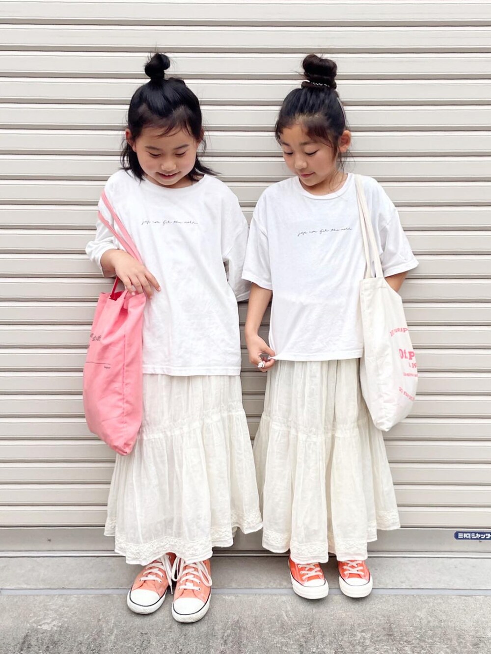 ホワイト系のスカート、ホワイト系のTシャツ/カットソー、ホワイト系のトートバッグを着用したキッズの秋コーディネートの2枚目の写真