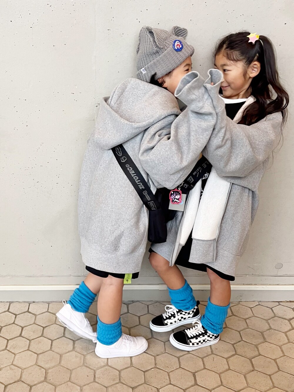 ブラック系のTシャツ/カットソー、ブラック系のショルダーバッグ、グレー系のパーカーを着用したキッズの冬コーディネートの3枚目の写真