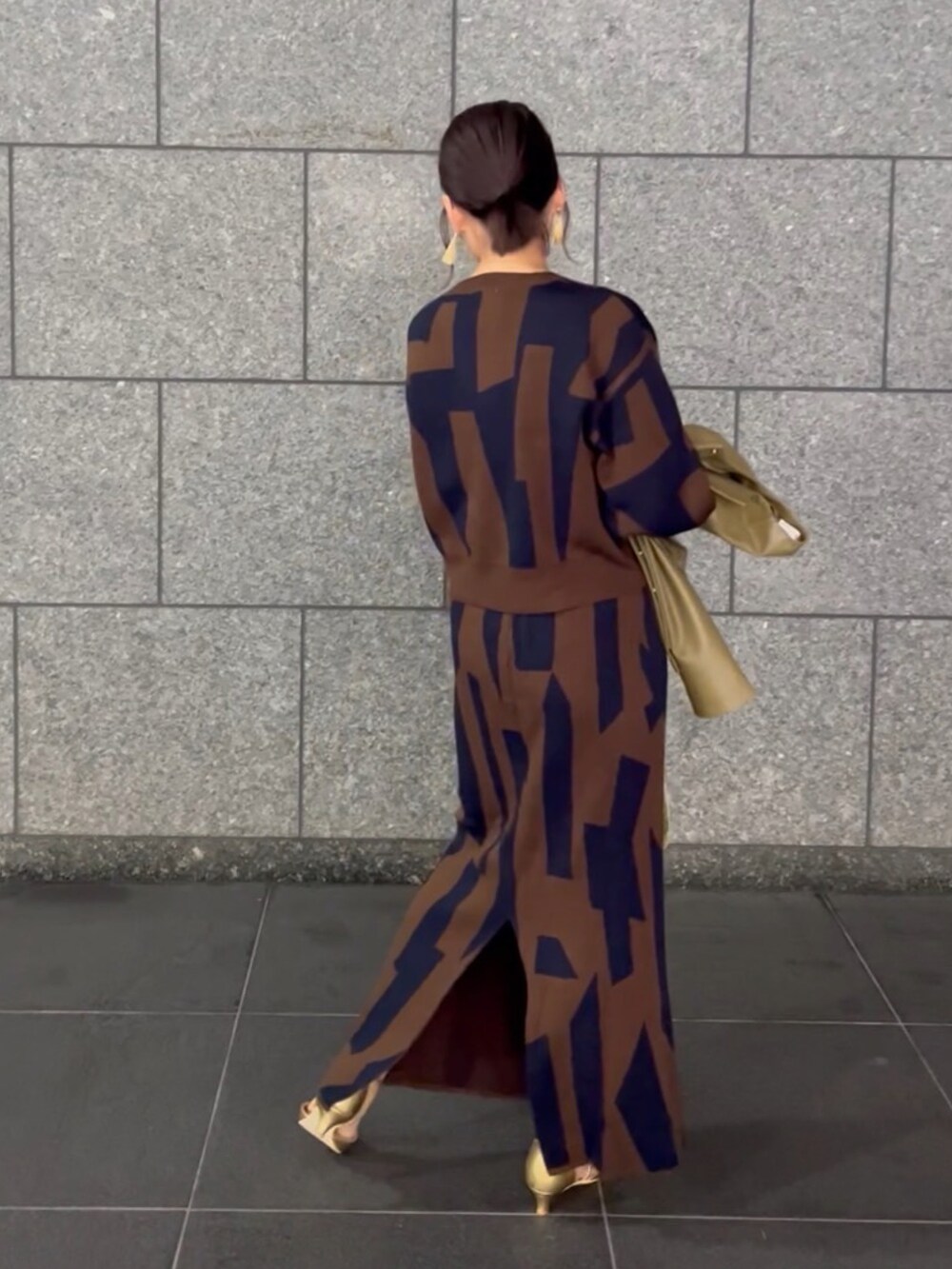 ブラウン系のスカート、ブラウン系のニット/セーター、グリーン系のノーカラージャケットを着用したレディースの秋コーディネートの2枚目の写真