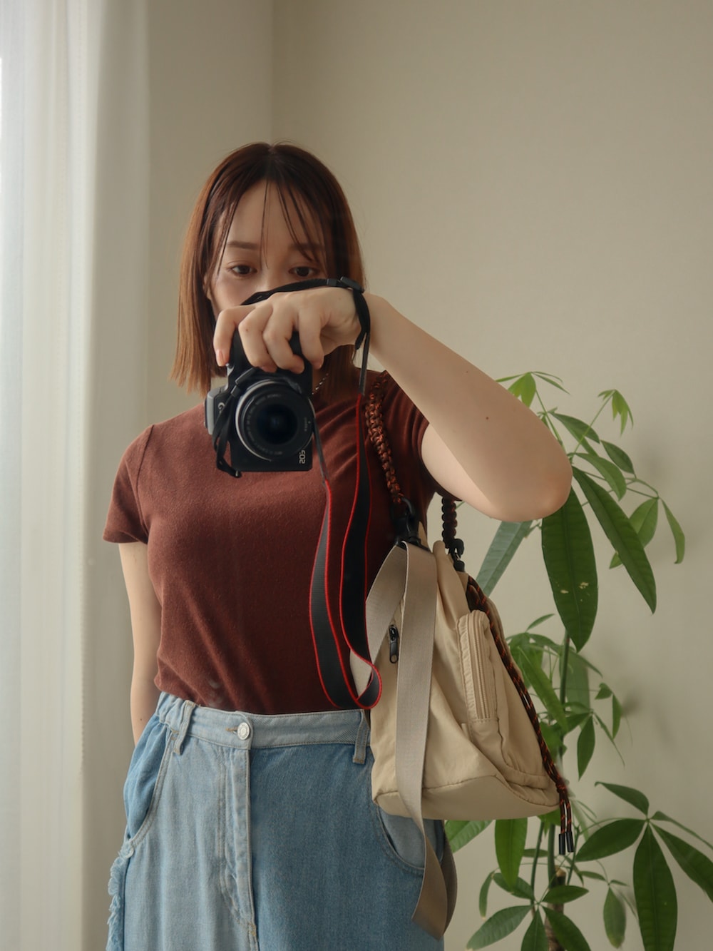 ブラウン系のTシャツ/カットソー、ベージュ系のトートバッグ、ブルー系のデニムスカートを着用したレディースの夏コーディネートの2枚目の写真