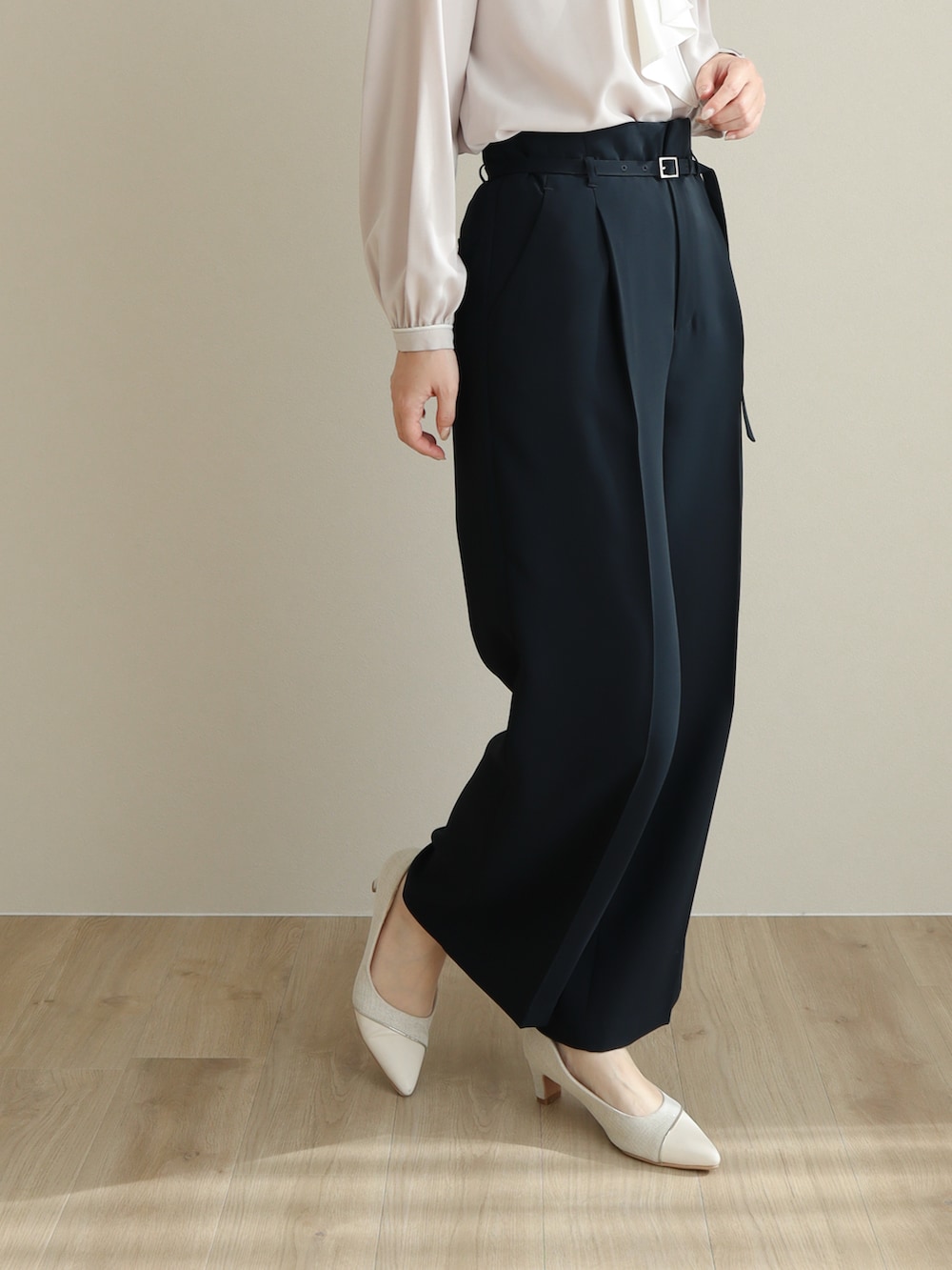 ブルー系のスーツセット、ピンク系のパンプス、ブラック系のバッグを着用したレディースの冬コーディネートの5枚目の写真