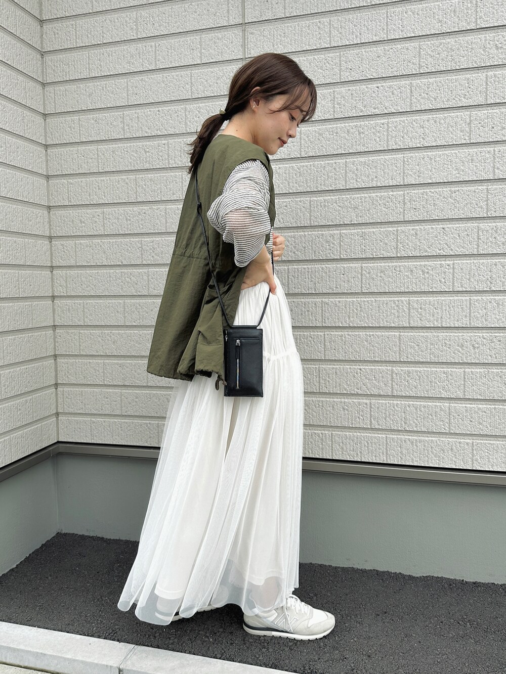 ホワイト系のTシャツ/カットソー、ホワイト系のスカート、ブラック系のショルダーバッグを着用したレディースの春コーディネートの2枚目の写真