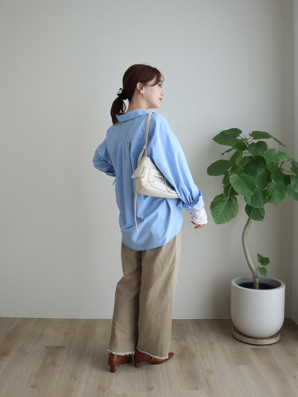 ブルー系のシャツ/ブラウス、ベージュ系のデニムパンツ、ホワイト系のトップスを着用したレディースの冬コーディネートの2枚目の写真