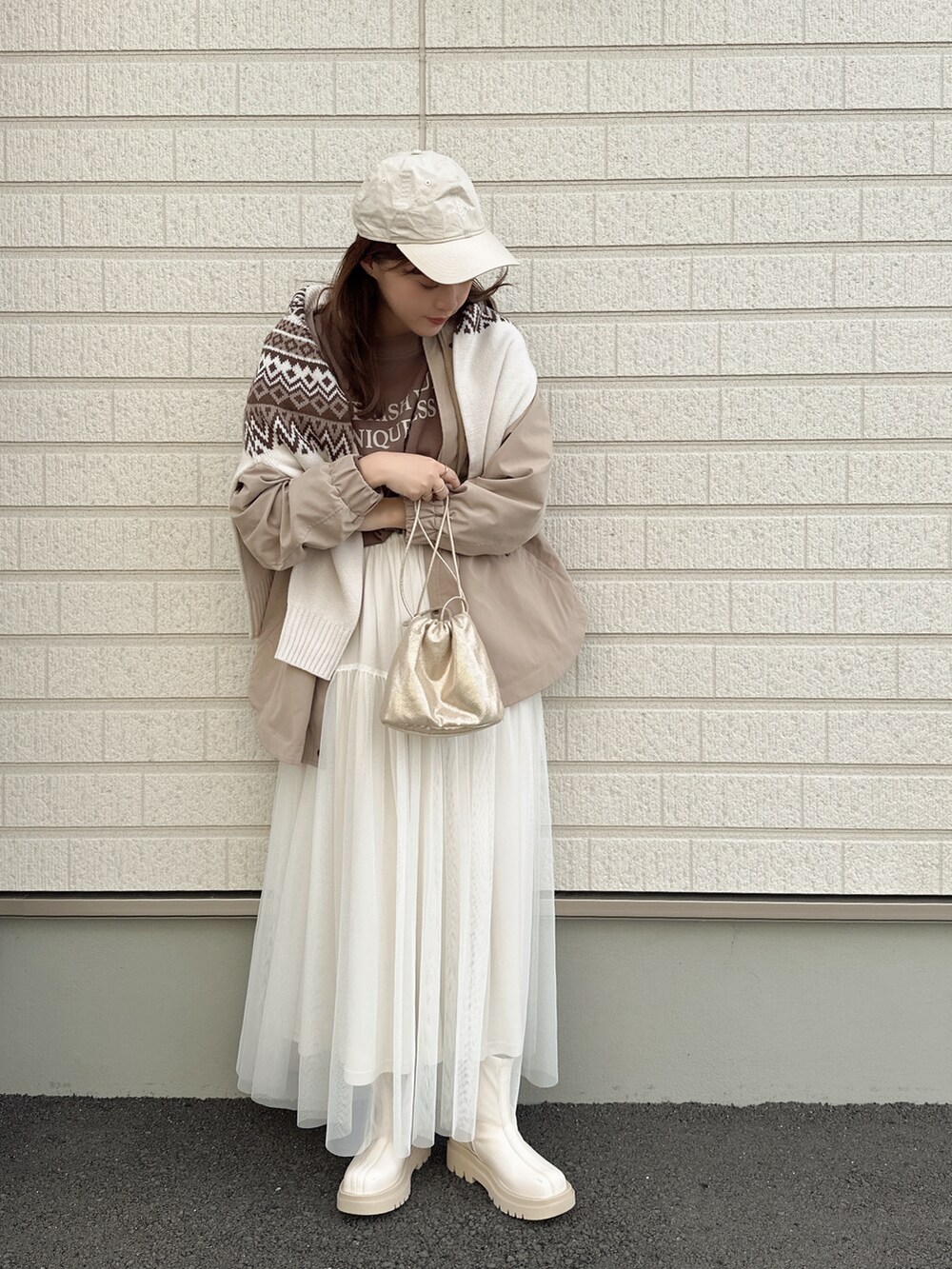 ホワイト系のニット/セーター、ベージュ系のジャケット/アウター、ホワイト系のスカートを着用したレディースの秋コーディネートの2枚目の写真