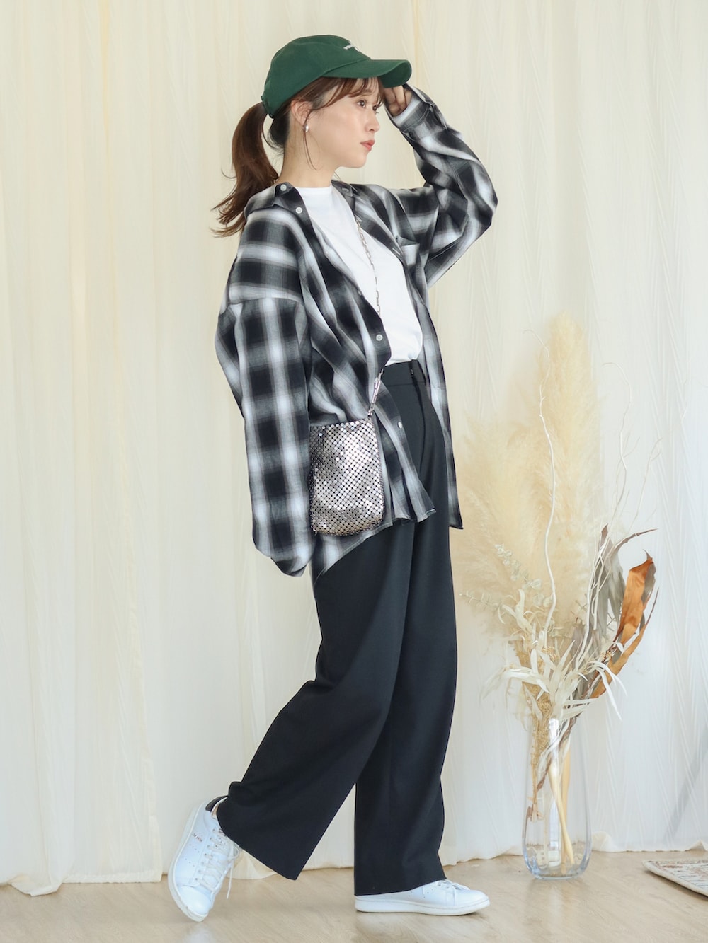 ブラック系のシャツ/ブラウス、シルバー系のショルダーバッグ、ホワイト系のスニーカーを着用したレディースの秋コーディネートの2枚目の写真